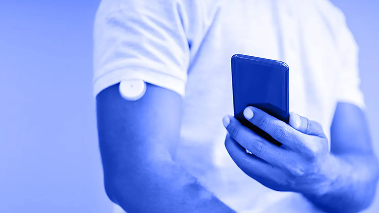 man using smartphone and blood monitor