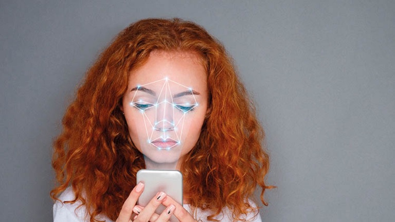 A person using smartphone while AI is scanning her face