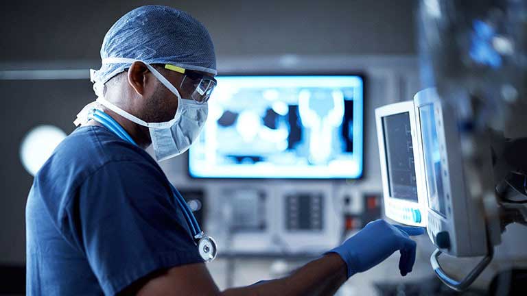 surgeon checking a patient's monitoring equipment