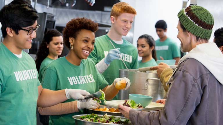 colleagues volunteering by serving food at a shelter