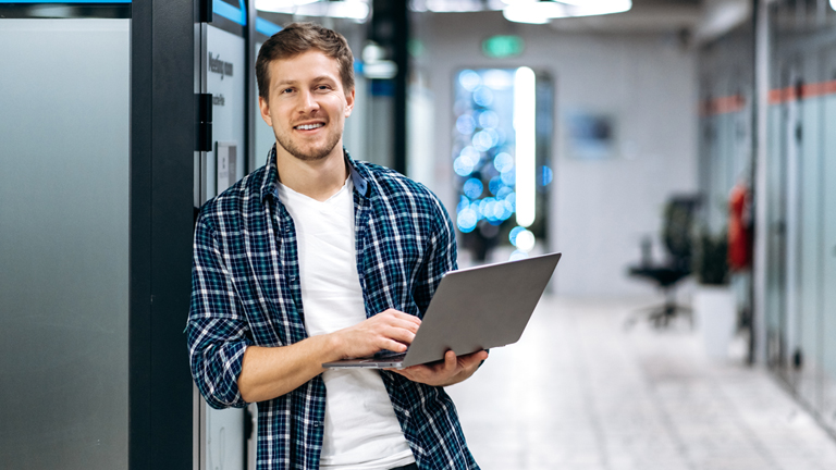 An employee holding laptop in the office