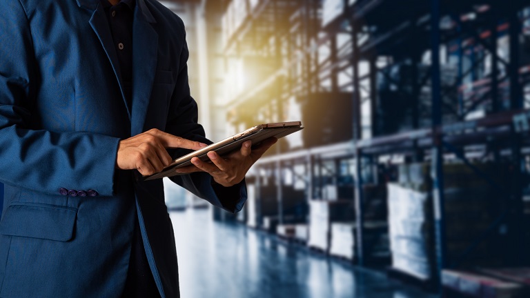 Employee checking on warehouse stock via tablet